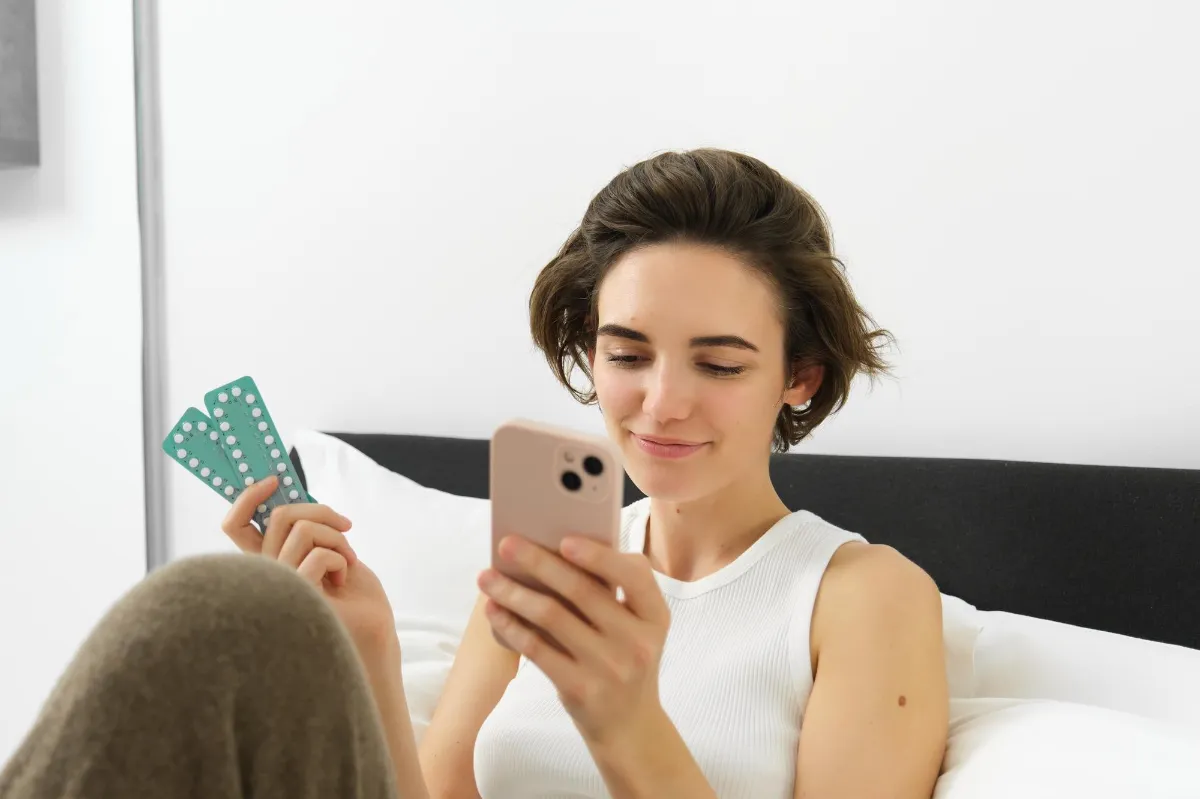 Portrait of smiling young woman reading on mobile phone searching medication dosage instruction her